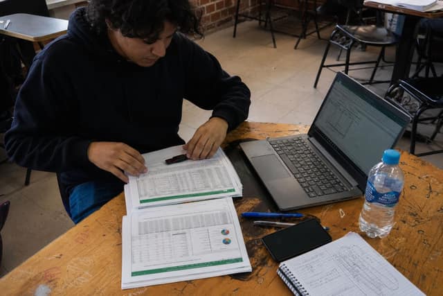 Estudiante organizando libros, USB y laptop de clase