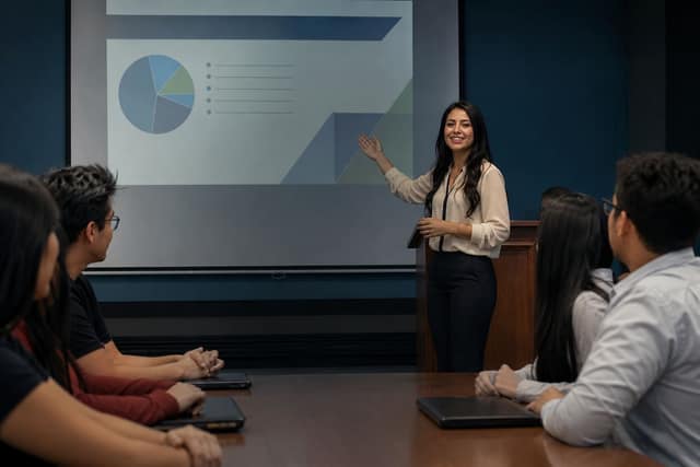 Estudiante mexicana exponiendo una presentación de PowerPoint en el aula